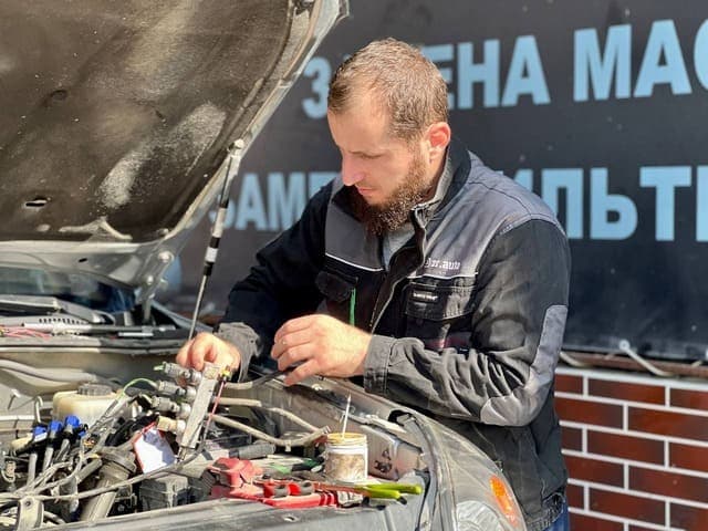 Мастер проверяет оборудование под капотом